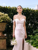 Model in garden wearing large teardrop pearl earrings suspended on a long silver bar